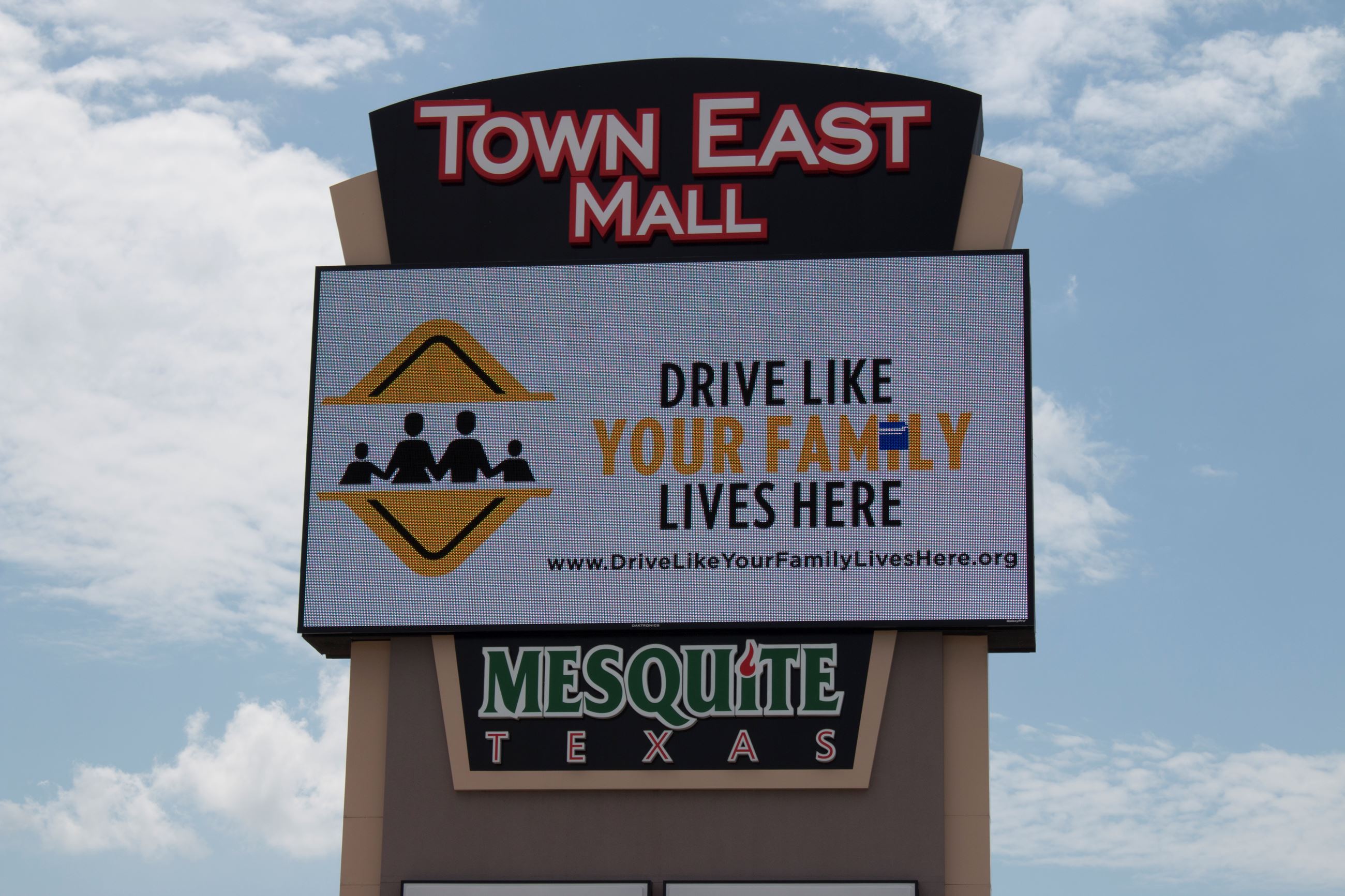 The Drive Like Your Family Lives Here logo displayed on the mall marquee