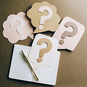 Collage of question marks and a notepad