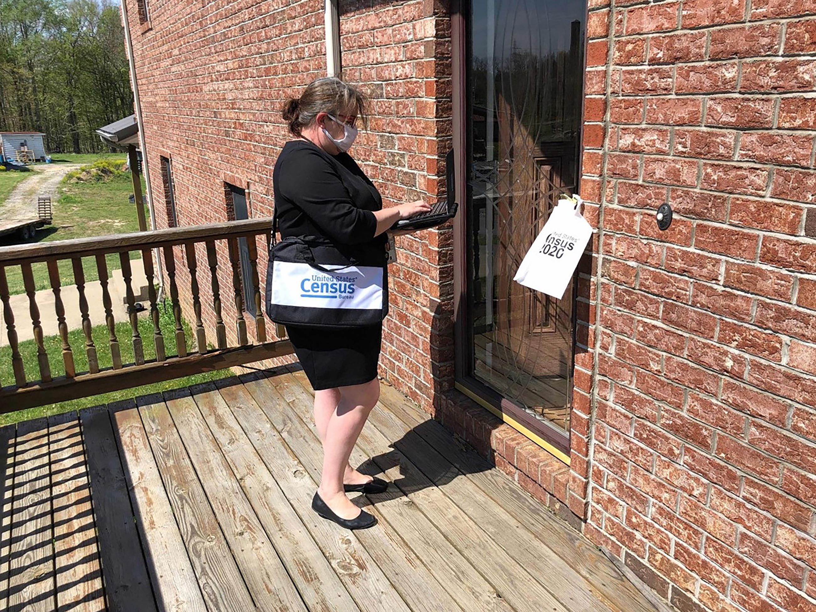 Census Worker Updates Address on Laptop