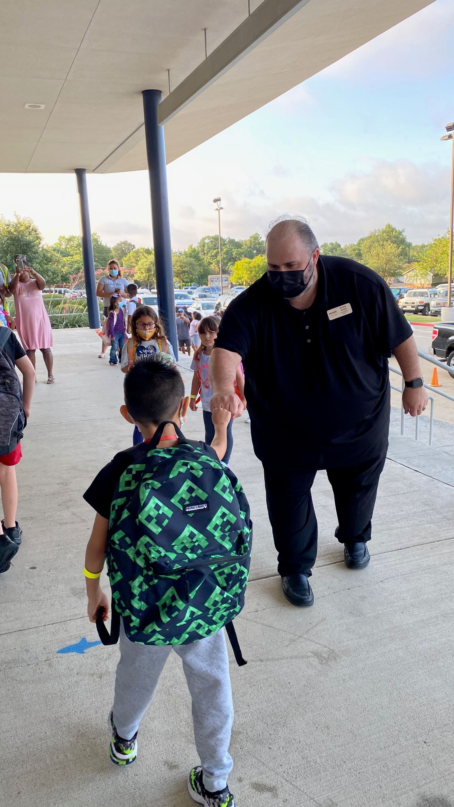 Kenny green fist bumps student