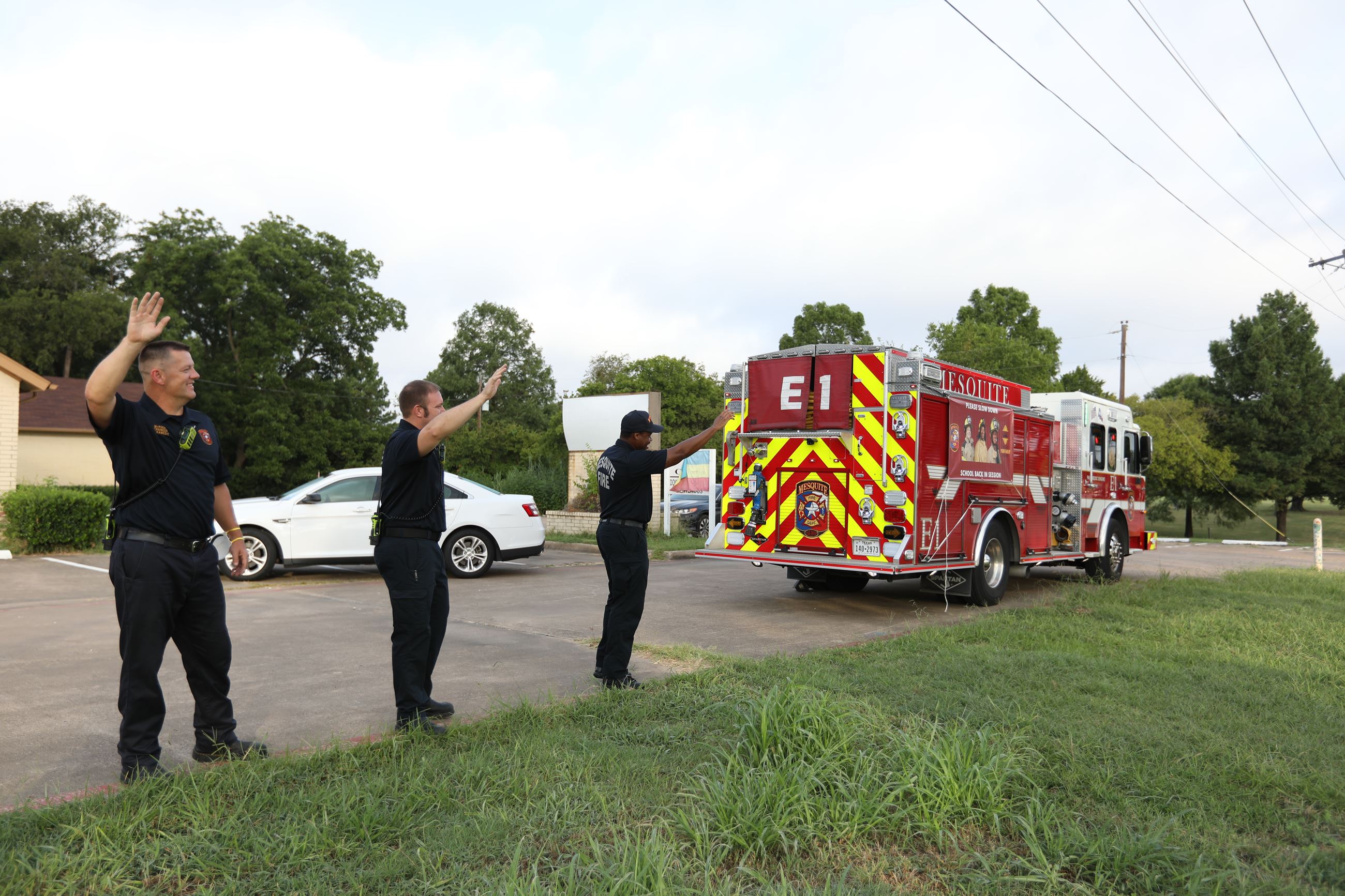 Firefighters wave to students
