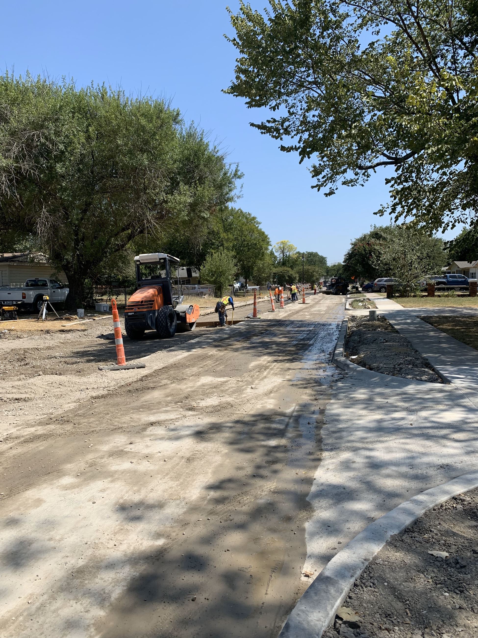 street crews work on residential street marked off with orange caution cones
